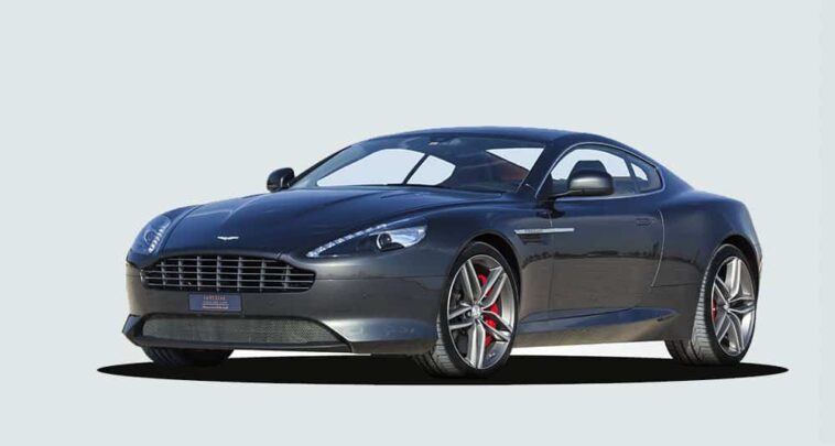 Dark metallic Aston Martin DB9 shown from the front three-quarter angle in a studio setting
